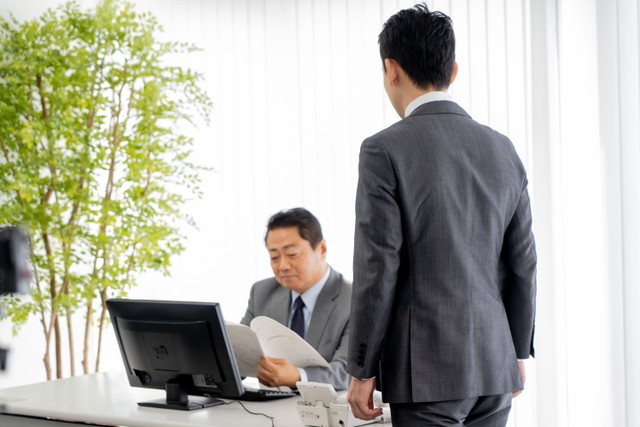 上司の席まで挨拶に行く社員　※画像はイメージです（ponta1414/stock.adobe.com）