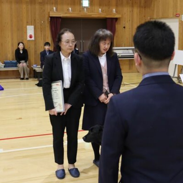 生徒代表（手前）から盲導犬育成のための寄付の目録を受ける関西盲導犬協会の関係者ら＝京都市伏見区・醍醐中