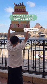 朝の光の中、風船を掲げる息子さん。まだ静かな広場の先に、キャストが姿を見せ始める／ゆっきーさん（@yuki.m.h）提供