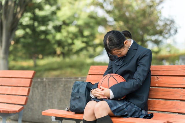 バスケットボールを持って悩む女子中学生※画像はイメージです（buritora/stock.adobe.com）