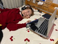 ベッドの上でパソコンを通じてロボットを操作する干場さん。「働くことで世界が広がった」と話す