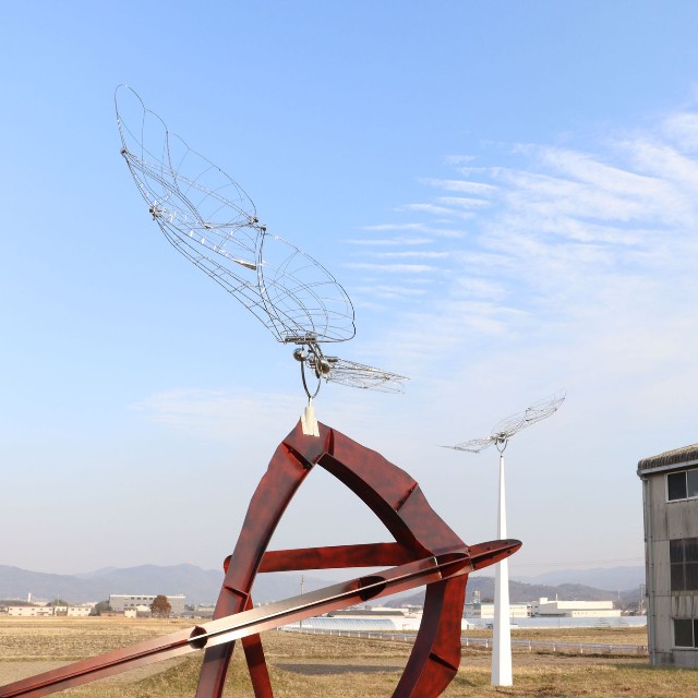 近づくと、硬質な構造体が風を受けてしなやかに舞っていた。右奥の工房で制作されたシリーズ「風になるとき」の作品だった