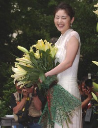 ユリの花を手に笑みを浮かべる常盤貴子＝2004年