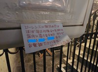 2階部分の鉄格子に貼られた電話番号が書かれた紙（「旅人YAMA」さん提供）