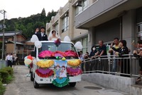 軽トラックの「オープンカー」に乗る２人を祝福する住民たち（宮津市小田）