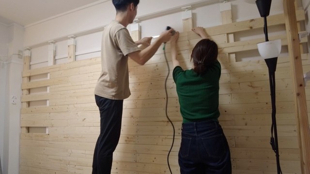 壁に板を張り付けている時の様子