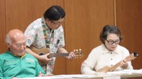 講師の水谷さん（中央）にウクレレの手ほどきを受ける参加者＝南丹市八木町・八木市民センター