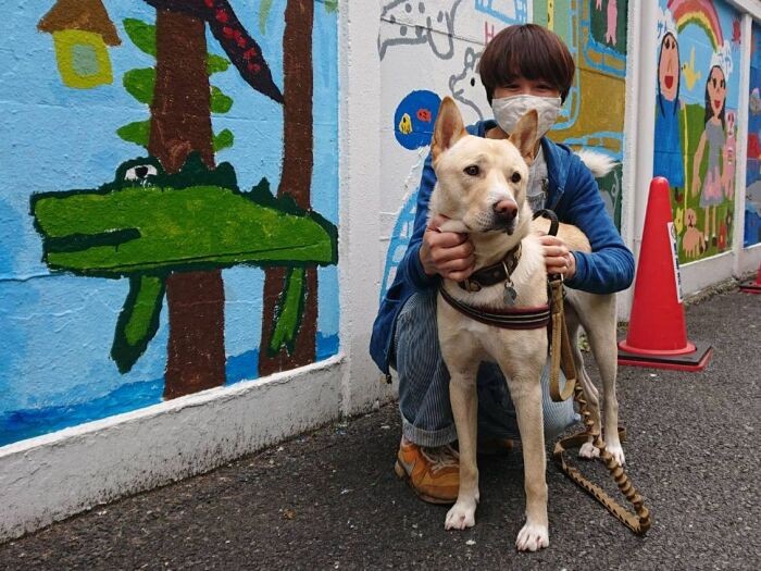 代々木アートスタジオ前で聖子先生と。壁画は毎年こどもたちが描き替えている。昨年はコロナで中止に。「自粛でこどもたちと会えない時、天ちゃんが心を和らげてくれました」と聖子先生。（鈴木先生提供）