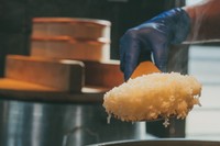 米屋がつくるおむすび屋「十字屋商店」では、真庭産の循環するお米（めぐりまい）を羽釜で炊いたおむすびや定食を。水車で24時間かけて行う精米は、精米時の熱を帯びないためふっくら柔らかく甘みのあるお米に炊き上がる（真庭あぐりガーデン提供）