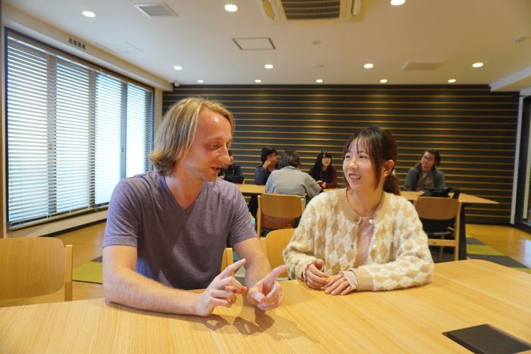 日本語学校「東洋言語学院」の学生マシュー・ペッパーさん（左）と王超敏さん=2025年10月、東京都内