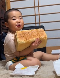 大きな食パンを抱えて誇らしげな男の子（提供：＠babyzo_osaruさん）