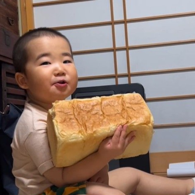 大きな食パンを抱えて誇らしげな男の子（提供：＠babyzo_osaruさん）