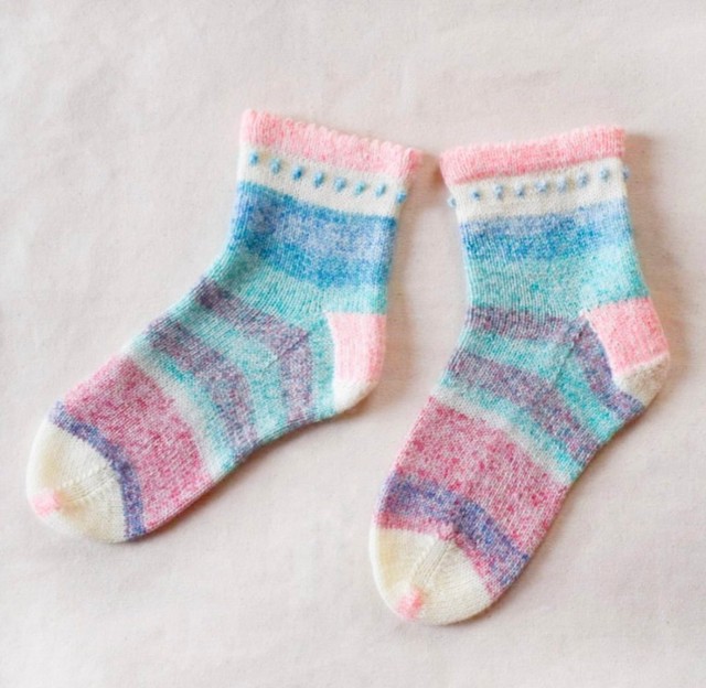 つま先とかかとを白い糸で編んだ靴下／risaさん（@koalove_knit）提供