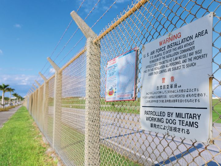 沖縄県の米軍基地を囲むフェンスに掲げられた警告