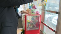 職員が路面電車の中にある販売機にカプセルを詰めた
