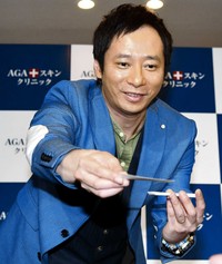 発毛大使の名刺を配るいしだ壱成＝2018年