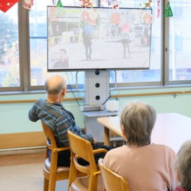 ガンマ波サウンドスピーカーを設置したテレビを視聴する入居者