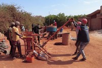 人力の圧縮機械を使い、土れんがをつくる「エレメンテール」の作業員ら＝2023年12月23日、セネガル西部、荒ちひろ撮影