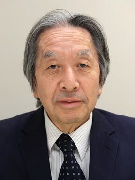 原昌宏さんの顔写真。グレーの背景で、白いシャツに濃紺のスーツ、紺地に小柄模様のネクタイを着用