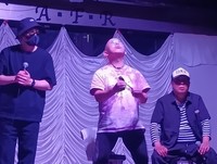 イベントでスプーン曲げを披露する清田益章氏（中央）＝横浜市内