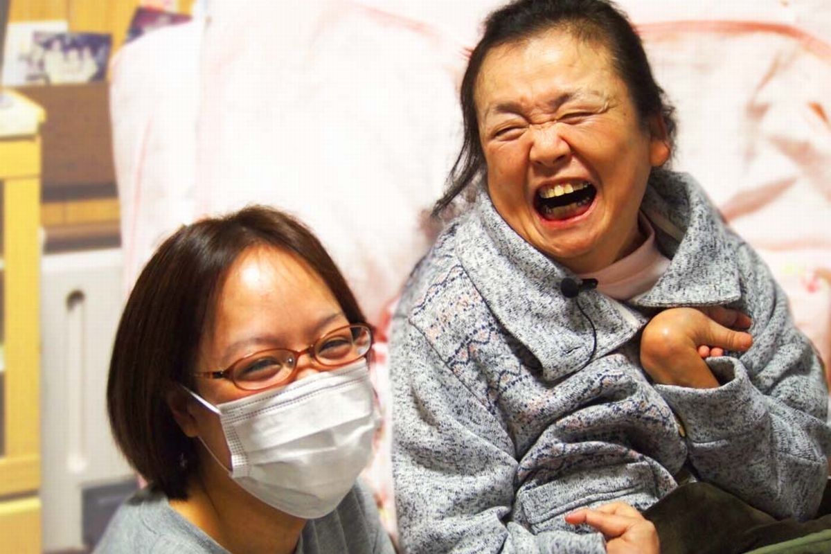 利用者とケアする職員（提供写真）