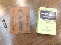 樋屋奇応丸のパッケージ。現在の物（右）と明治時代とみられる物（中央）。いずれも中には小さな瓶詰めの丸薬（左）が入っている（大阪市北区・樋屋製薬）
