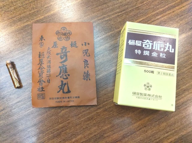 樋屋奇応丸のパッケージ。現在の物（右）と明治時代とみられる物（中央）。いずれも中には小さな瓶詰めの丸薬（左）が入っている（大阪市北区・樋屋製薬）
