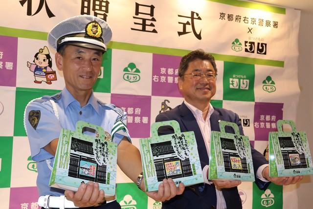 交通安全を呼びかける商品を手に持つ西谷真嗣右京署長（左）と森義治社長＝京都市右京区・嵐電嵐山駅はんなり・ほっこりスクエア