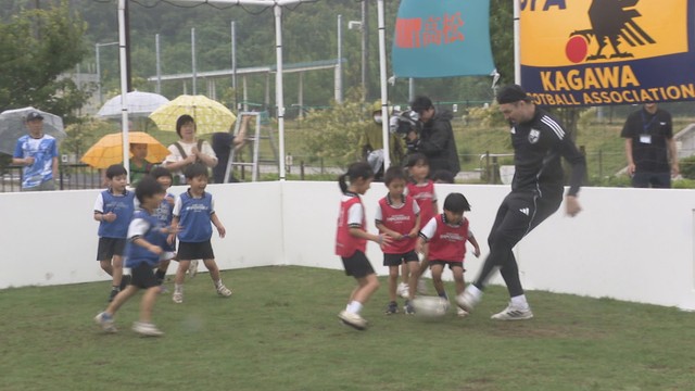 キッズピッチでサッカーを楽しむハーフナー・マイクさんと園児