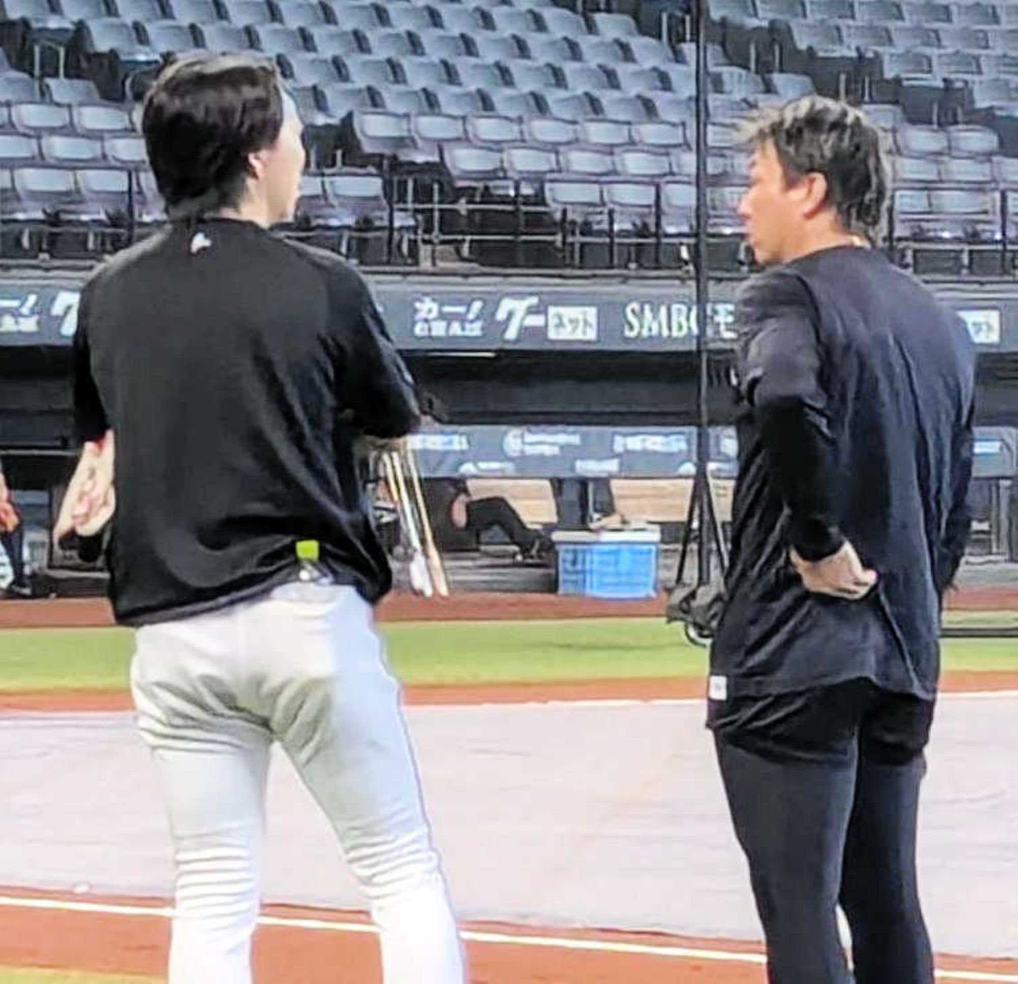 試合前の練習中に益田(右)と話す宮西＝8月28日