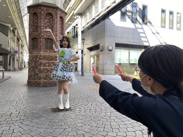 ハートを射抜くように光る棒を振る記者