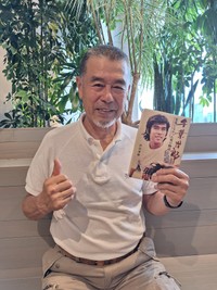 「仮⾯ライダー」で滝和也を演じた若き日の姿が表紙になった初の著書を手にする77歳の千葉治郎（前⽥満穂氏）＝都内