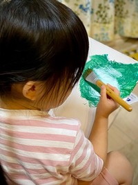 緑色の絵の具を塗っていく（添田一平さん提供）