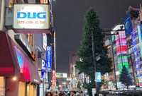 新宿の夜景に浮かぶ老舗ジャズ喫茶「DUG」の看板。ロゴはイラストレーター・和田誠さんが手掛けた