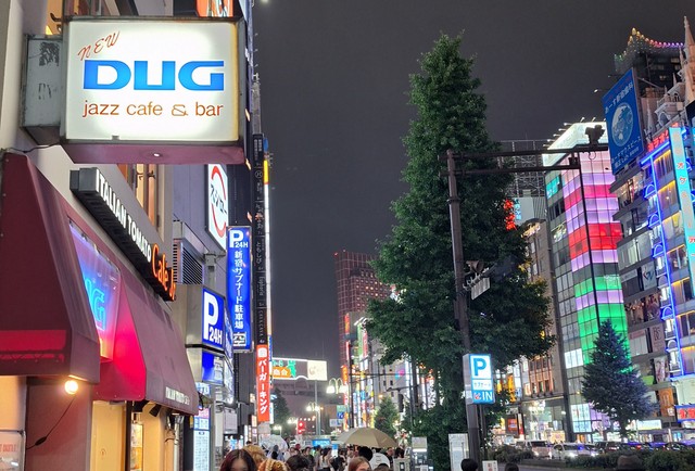 新宿の夜景に浮かぶ老舗ジャズ喫茶「DUG」の看板。ロゴはイラストレーター・和田誠さんが手掛けた