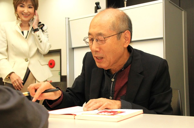 楽しく会話をしながらサインしていく桐谷さん。