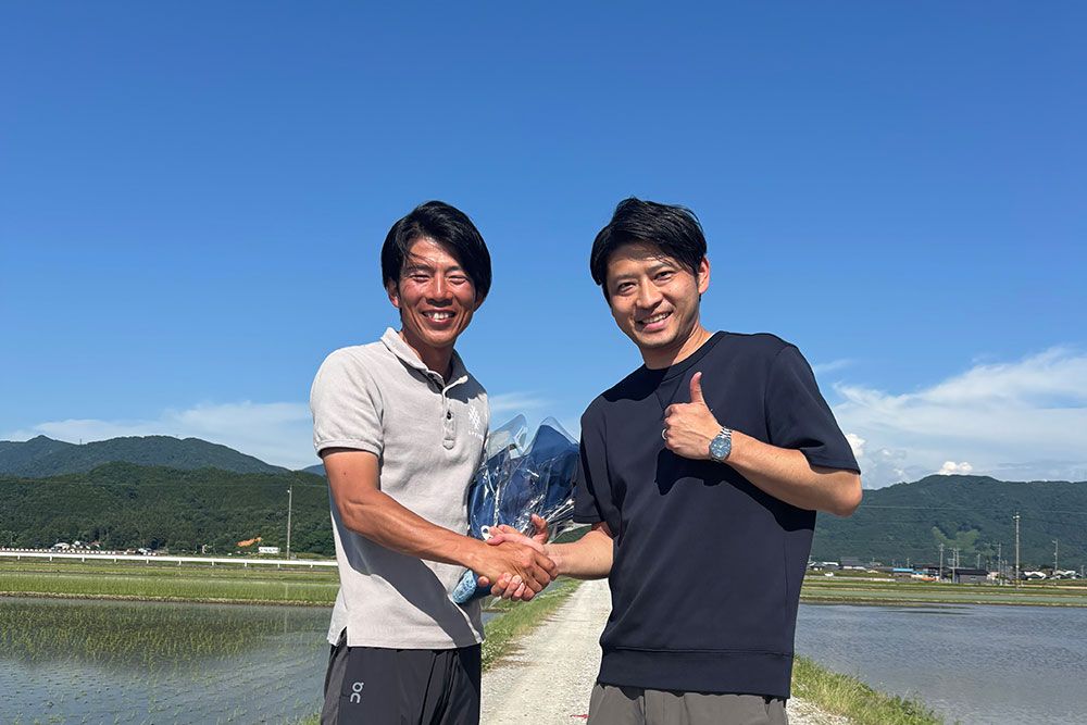 米づくりの現場で固い握手を交わす宮嵜恵介さん(左)と一番搾りブランドマネージャーの佐藤洋介さん(右)