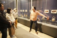 来館者に展示品の解説をする森下館長（右）