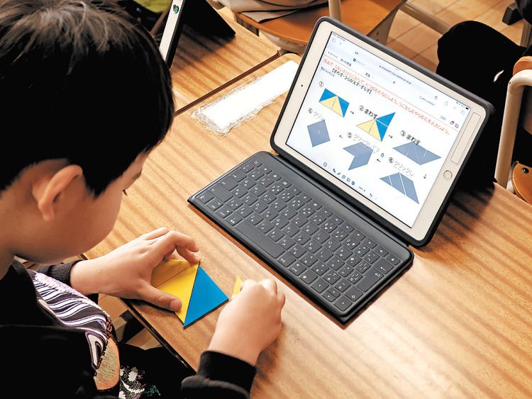 タブレット端末を使い、手も動かしながら図形について学ぶ児童