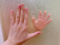 お風呂の扉越しに手を重ねる息子さんとママむに@2yさん（@munimuni_baby）