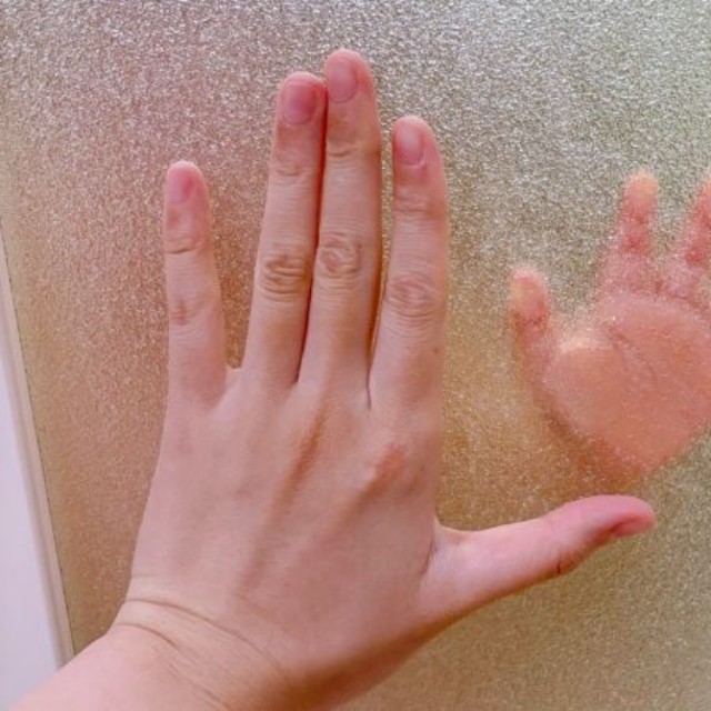 お風呂の扉越しに手を重ねる息子さんとママむに@2yさん（@munimuni_baby）