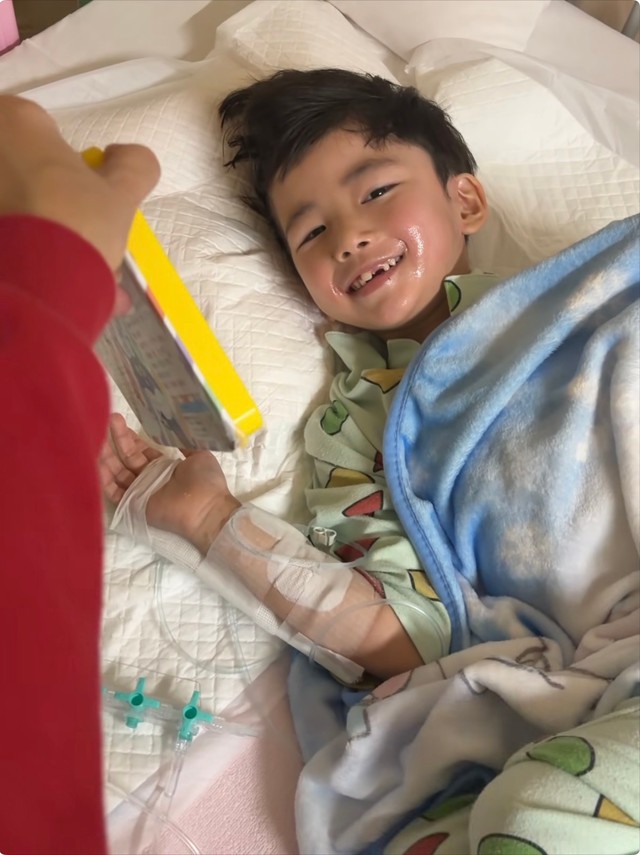 音の出る絵本を見て微笑むれおくん／ᴍɪ-ᴋᴏさん（@lk_mkbbpnsk_kl）提供