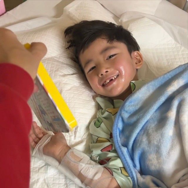 音の出る絵本を見て微笑むれおくん／ᴍɪ-ᴋᴏさん（@lk_mkbbpnsk_kl）提供