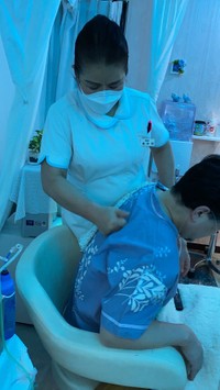 水素吸入と足湯デトックスの間、施術する楊珍雲院長の拳が背中にめり込む＝東京・新橋の珍雲堂本店