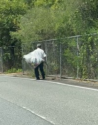 道路脇で、大きな袋を抱えながら歩く」ワイシャツにスラックス姿の男性の姿が…