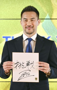 引退記者会見で「挑戦」と書いた色紙を手にするサッカー元日本代表の岡崎慎司（共同）