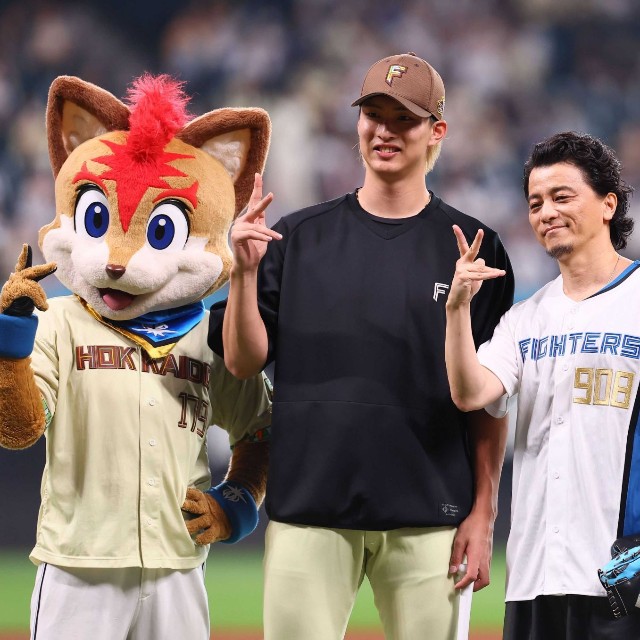 KREVA(右)と記念撮影に応じる日本ハム・達孝太＝エスコンフィールド北海道