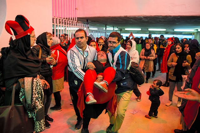 A female football fans passes out after Iran's Perspolis losses the AFC Championship League cup to Japan's Kashima Antlers in Tehran.