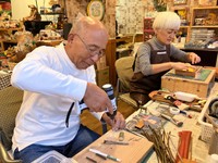 机を並べ作業に没頭する哲朗さん（左）と真理子さん。それぞれの得意分野を生かしアイデアを出し合う