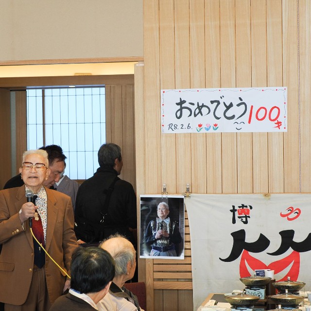 2月6日、100歳の誕生日を迎え、百寿を祝う会が開催された。地元テレビ局も取材するなか、集まった仲間たちに感謝の意を表する乱万さん